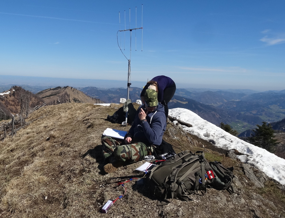 OE5LXR on mountaintop broadcasting using portable ham radio.
